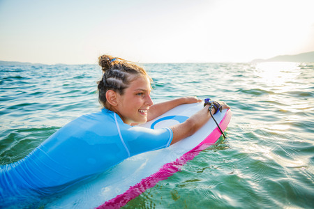 Young surfer girl is lerning to ride a wave.