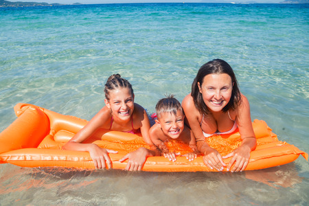 Summer vacation concept - Happy child with mother playing in sea.の写真素材