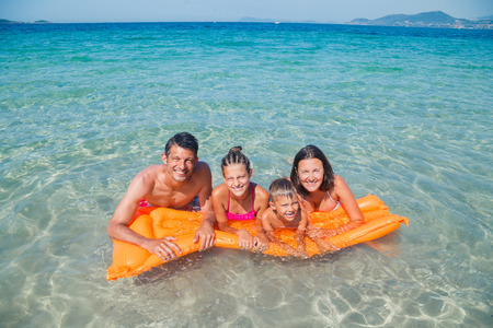 Summer vacation concept - Happy family playing in sea.の写真素材