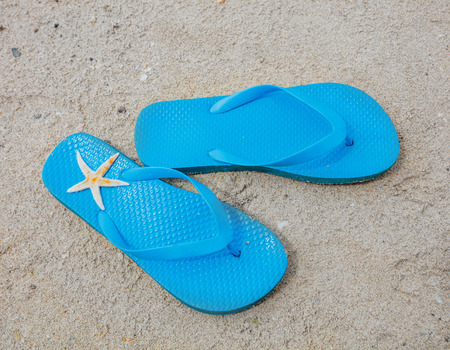 Female Rubber Heel-Strap Sandals And Starfish On The Summer  Beach Close-up.
