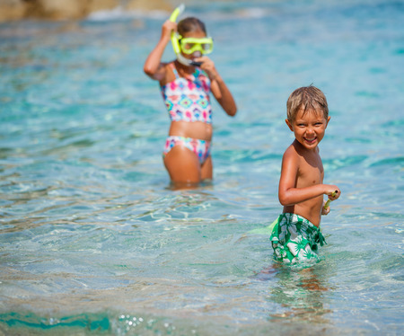 Joyful boy with his sister on the tropical beach going to scuba diving.の写真素材