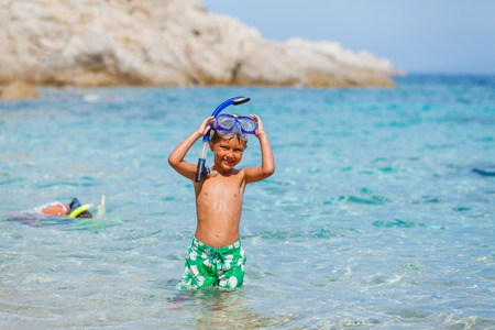 Joyful boy with his sister on the tropical beach going to scuba diving.の写真素材