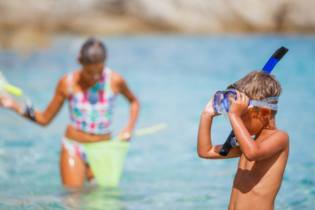 Joyful boy with his sister on the tropical beach going to scuba diving.の写真素材