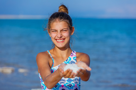 Portrait of beautiful girl hands with sea salt for spa from Dead Sea. Israelの写真素材