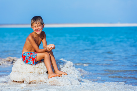 Cute boy hands with sea salt for spa from Dead Sea. Israelの写真素材