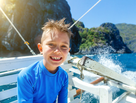 Cute boy on a boat at a sunny summer day. Philippinesの写真素材
