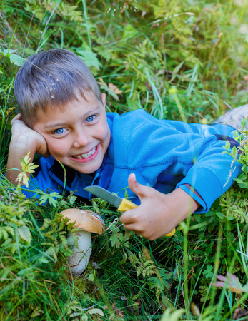 Boy with wild mushroom found in the forestの写真素材