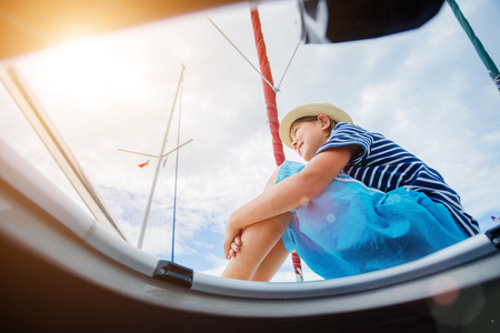 Little boy on board of sailing yacht on summer cruise. Travel adventure, yachting with child on family vacation.の写真素材