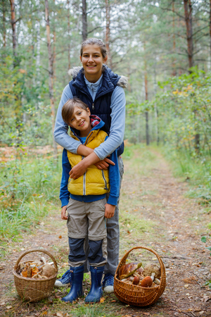 Mushrooms picking, season for mushrooms - lovely kids with picked fresh edible mushroomsの写真素材