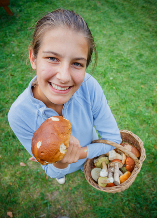 Cute girl with wild mushroom found in the forestの写真素材
