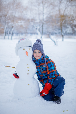 Boy with his self created snowman.の写真素材