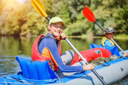 Happy girl kayaking on the river on a sunny day during summer vacationの写真素材