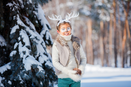 Portrait of smiling boy with funny antlers of a deer. Holiday concept.の写真素材
