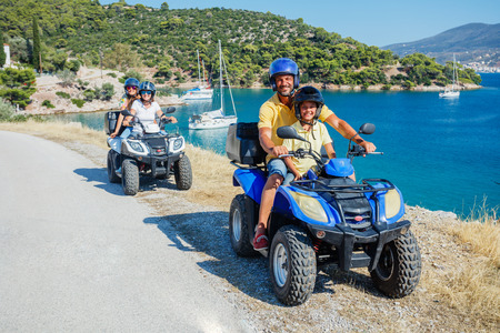 Family riding quad bike. Cute boy and his father on quadricycle. Motor cross sports on Greece island. Family summer vacation activity.の写真素材
