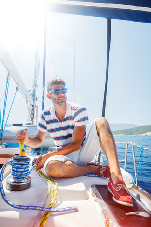 Young man sailing yacht. Holidays, people, travelの写真素材