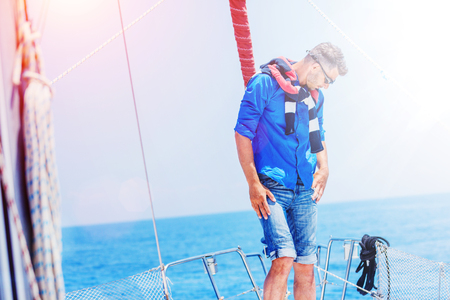 Young man sailing yacht. Holidays, people, travelの写真素材