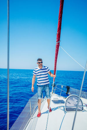 Young man sailing yacht. Holidays, people, travelの写真素材