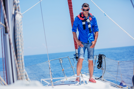 Young man sailing yacht. Holidays, people, travelの写真素材