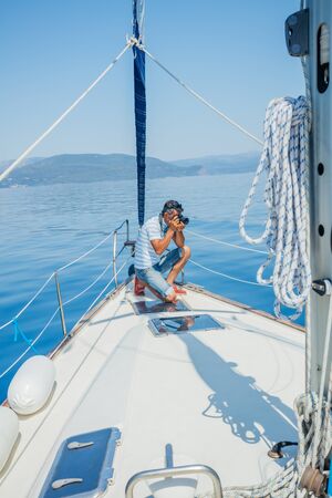 Young man making photo on the yacht. Holidays, people, travel