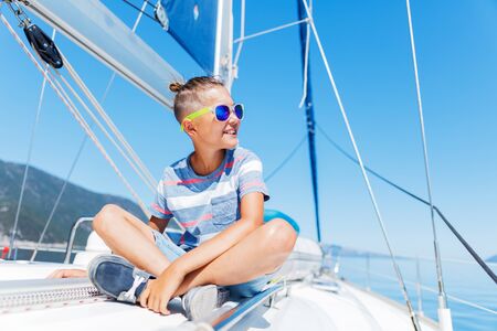 Little boy on board of sailing yacht on summer cruise. Travel adventure, yachting with child on...