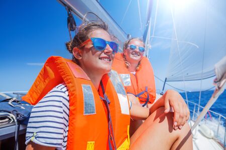 Two Young beautiful girls on board of sailing yacht on summer cruise in Greece. Travel adventure,...
