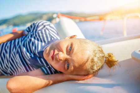 Little boy on board of sailing yacht on summer cruise. Travel adventure, yachting with child on family vacation.の写真素材
