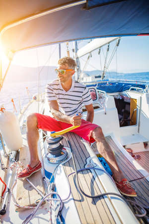 Young man sailing yacht. Holidays, people, travelの写真素材