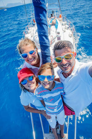 Family with adorable kids resting on yachtの写真素材