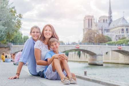 Happy family having fun near Notre-Dame cathedral in Paris. Tourists enjoying their vacation in France.の写真素材