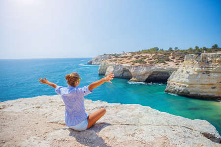 Girl looking out on the ocean. Lagos, Algarve Coast, Portugalの写真素材