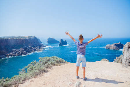 Boy looking out on the ocean. Lagos, Algarve Coast, Portugalの写真素材