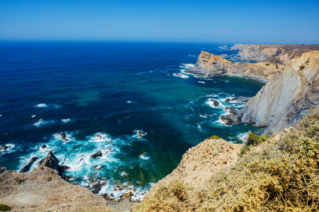 Rock cliff arches on beach and turquoise sea water on coast of Portugal.の写真素材