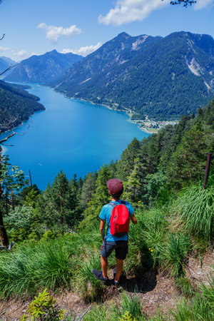 Hiker in the Alps. Boy backpacker tourist hiking at Lake.の写真素材