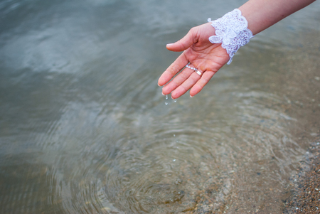 Water dripping from the hands of a bride in a riverの写真素材
