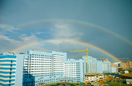 The rainbow stretches over the high-rise buildings of the city.の写真素材