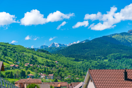 Snow-covered mountains are located near the village.の写真素材