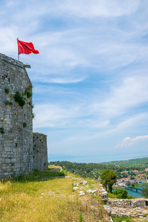 Albanian red flag with a black double-headed eagle towers above the fortress of Rozafa.の写真素材