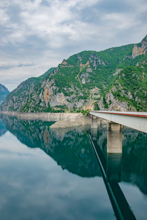 The big bridge is crossed by a picturesque mountain lake.の写真素材
