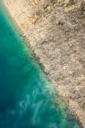 A picturesque place where transparent turquoise water meets a stony shore.の写真素材