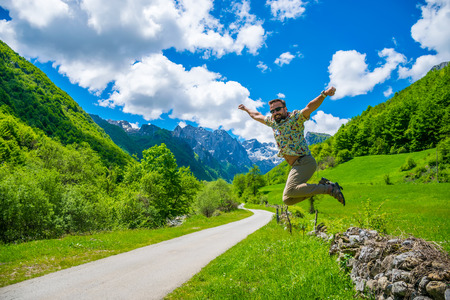 MONTENEGRO, PROKLETIJE MOUNTAINS - MAY 29/2017: tourists joyfully jump up against the background of snow-capped mountains.のeditorial素材