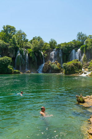 BOSNIA AND HERZEGOVINA, LYUBUSHKI - JUNE 01/2017: tourists rest and swim in the picturesque waterfall.のeditorial素材