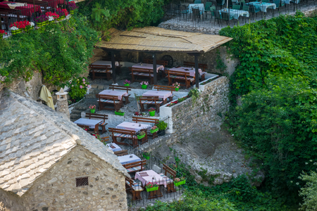 BOSNIA AND HERZEGOVINA, MOSTAR â JUNE 01/2017: tourists visited the restaurant, the tables of which are located on the narrow streets of the city.のeditorial素材
