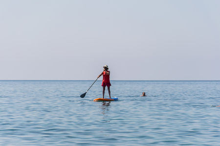 MONTENEGRO, BUDVA - JUNE 05/2017: tourists are engaged in rowing on the board (SUP) on the surface of the calm sea.のeditorial素材
