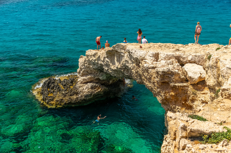 CYPRUS, THE BRIDGE OF LOVERS - MAY 11/2018: Tourists jump from a height into the azure waters of the Mediterranean Sea.のeditorial素材