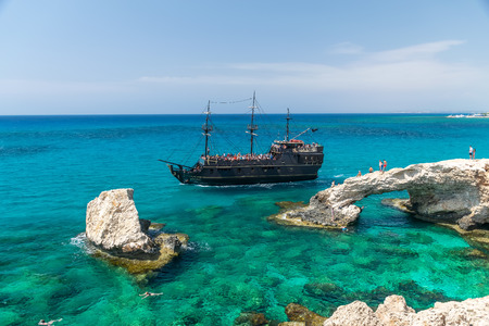 CYPRUS, AYIA NAPA - MAY 11/2018: tourists float on the ship near the most popular attraction - the Bridge of Love.のeditorial素材