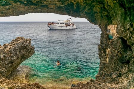 CYPRUS - MAY 11/2018: Tourists sailed on a sightseeing boat to a cave on the Mediterranean coast.のeditorial素材