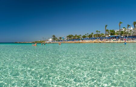 CYPRUS, NISSI BEACH - MAY 12/2018: Tourists relax and swim on one of the most popular beaches on the island.のeditorial素材