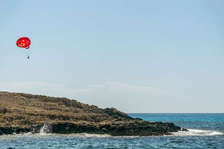 CYPRUS, NISSI BEACH - MAY 12/2018: Tourists are parasailing along the Mediterranean coast.のeditorial素材