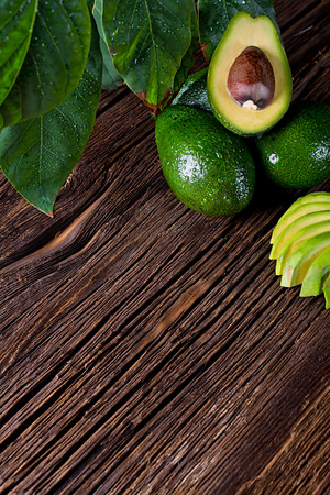 Avocado split in half on old wooden table with free space for your text. Top view.の写真素材