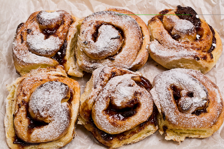 Homemade fresh baked yeast buns with plum jam. Sprinkled with icing sugar.の写真素材